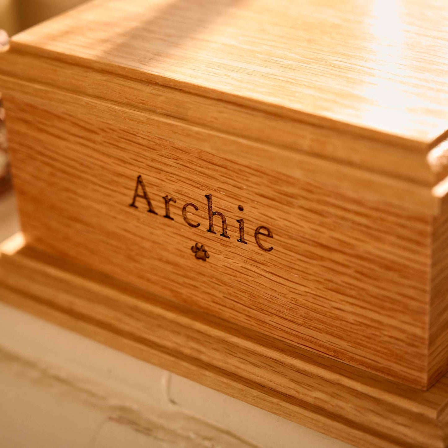 Close-up of engraved oak wood pet cremation urn – detailed view of custom memorial