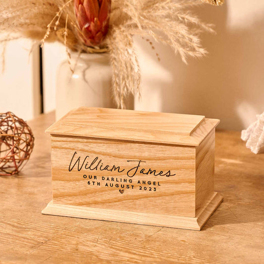 Personalised wooden cremation urn for stillborn baby with custom engraving.