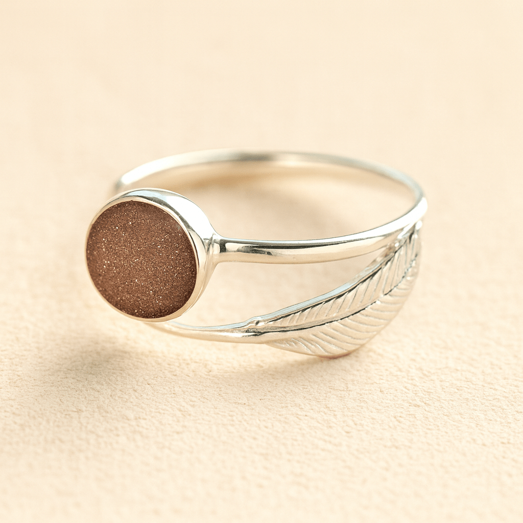 Adjustable Silver feather ashes ring with a mocha resin on a beige background