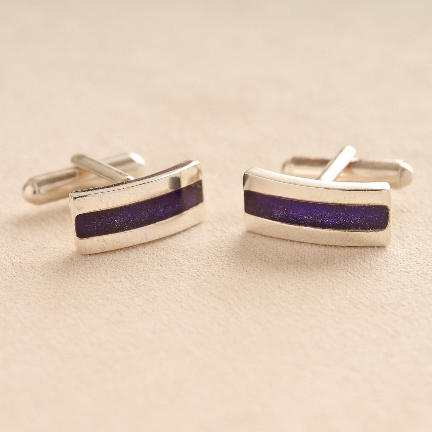 Silver Curved Ashes cufflinks with purple resin inlay with cremation ashes or fur on a beige background