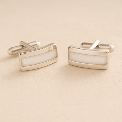 Silver Curved memorial cufflinks with white resin inlay with cremation ashes or fur on a beige background
