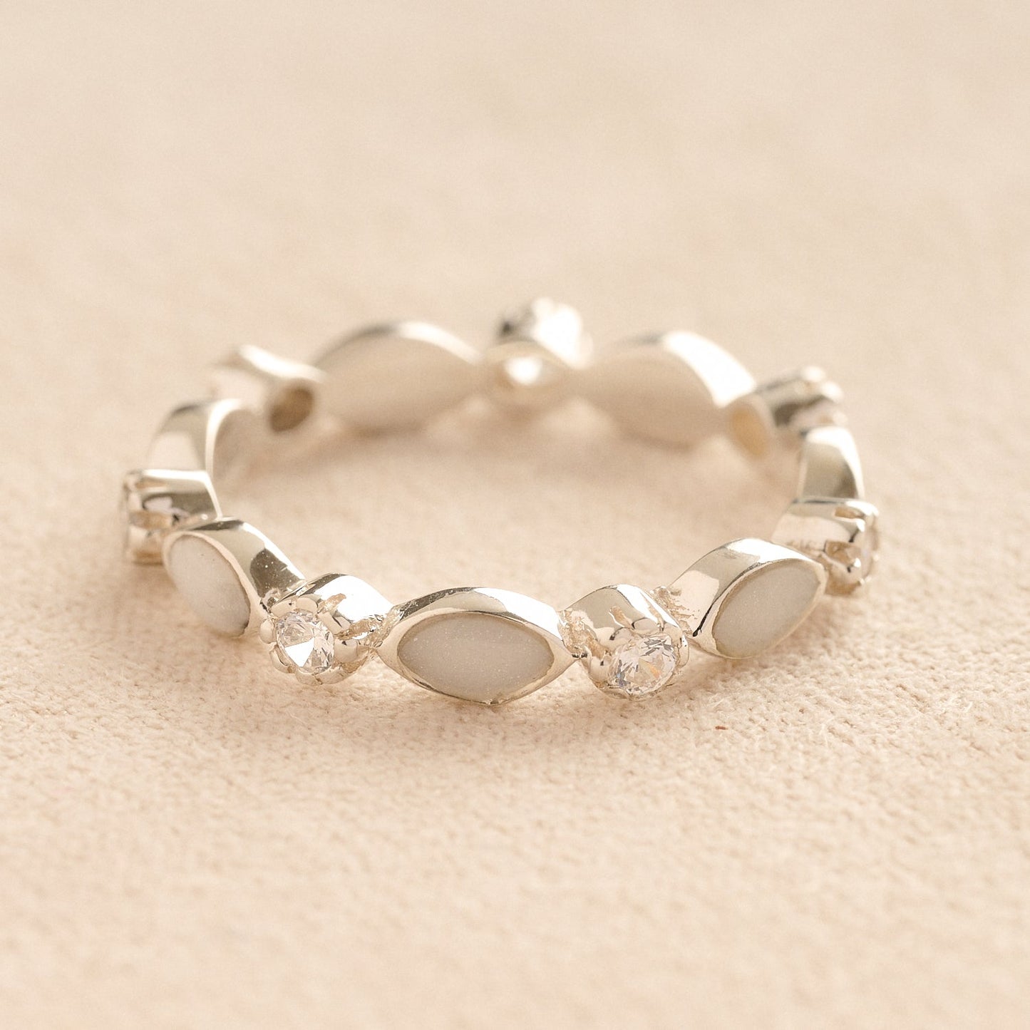 Silver cremation ashes ring with white resin and crystal accents, filled with ashes or fur, displayed on a soft beige background – suitable for pet or human memorials.