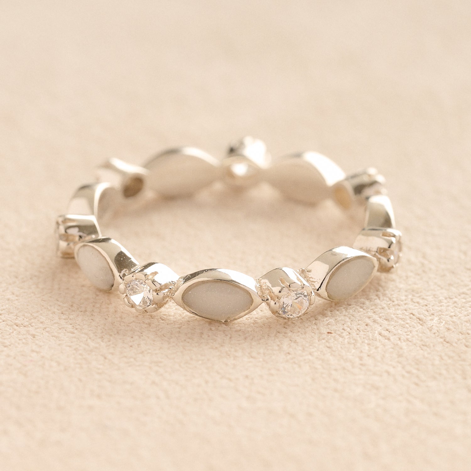 Silver cremation ashes ring with white resin and crystal accents, filled with ashes or fur, displayed on a soft beige background – suitable for pet or human memorials.