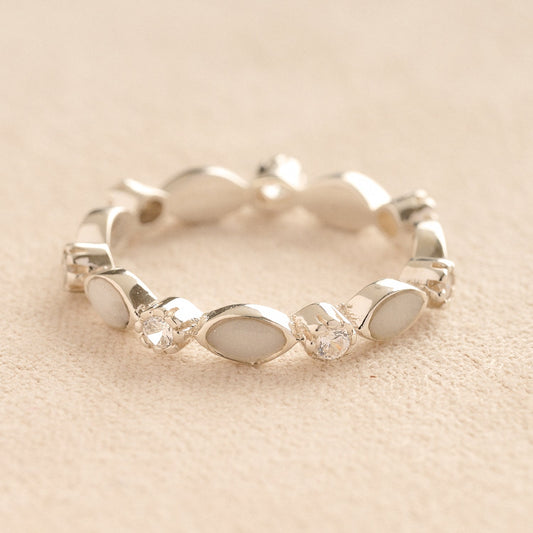 Silver cremation ashes ring with white resin and crystal accents, filled with ashes or fur, displayed on a soft beige background – suitable for pet or human memorials.