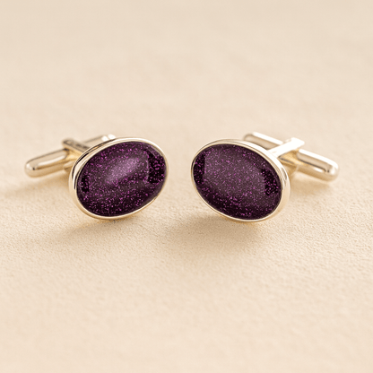 Silver oval cremation ashes cufflinks with a purple resin infill made with ashes or fur on a beige background