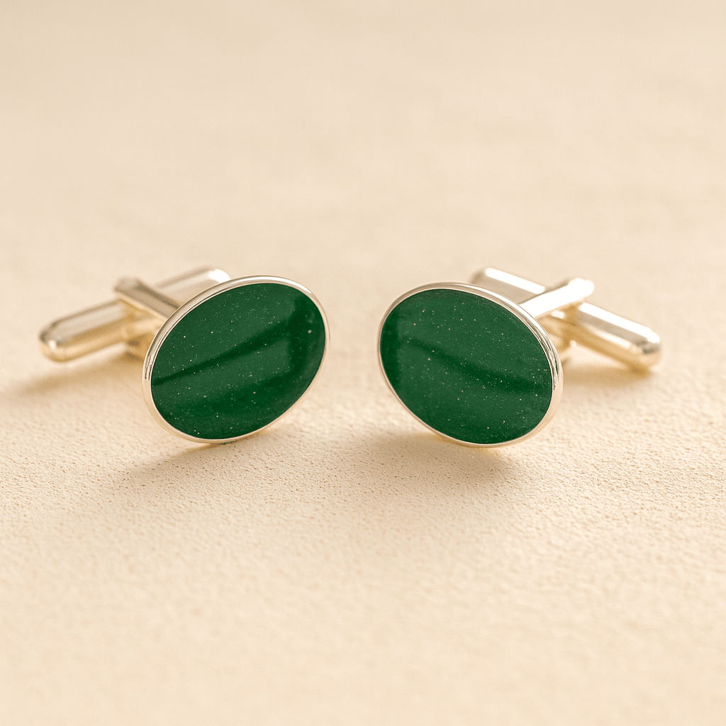 Silver oval memorial cufflinks with a dark green resin infill made with ashes or fur on a beige background