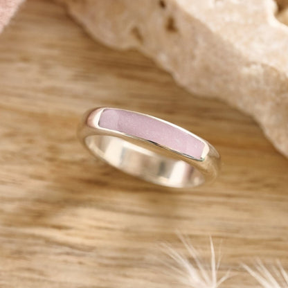 Sterling silver cremation ashes ring with lavender resin on a wooden table