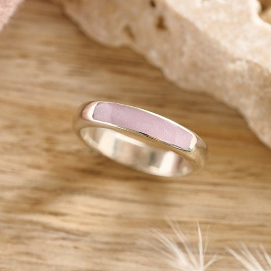 Sterling silver cremation ashes ring with lavender resin on a wooden table