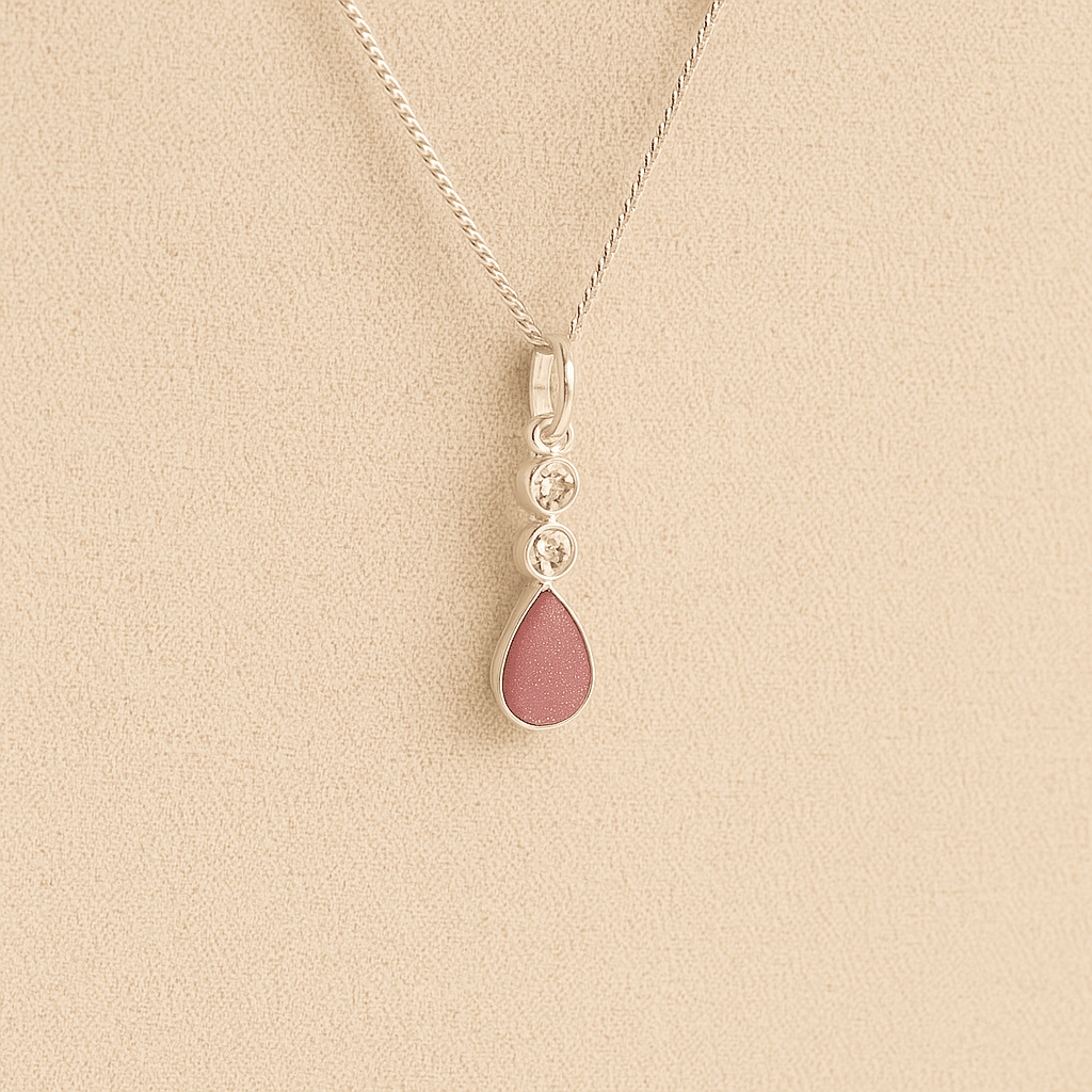 Silver Cremation ashes necklace with a teardrop pendant and dark pink resin filled with ashes or fur, displayed on a soft beige background – suitable for pet or human memorials.