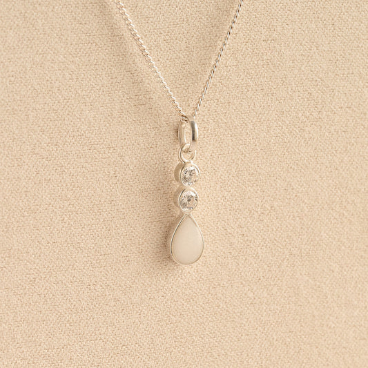 Silver Cremation ashes necklace with a teardrop pendant and white resin filled with ashes or fur, displayed on a soft beige background – suitable for pet or human memorials.