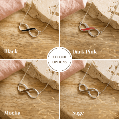 Four color options of an infinity ashes necklace on a wooden surface.
