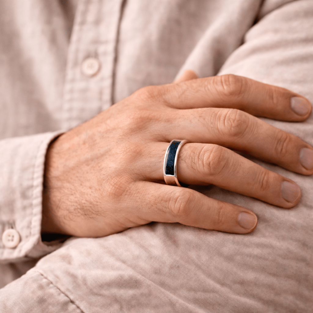 A man wearing an ashes ring with navy resin infill for ashes, hair or fur