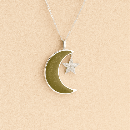 Moon and Star Memorial Necklace with sage resin filled with ashes or fur on a beige textured background