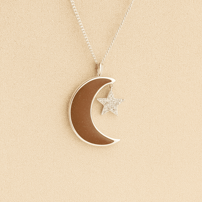 Moon and Star Memorial Necklace with mocha resin filled with ashes or fur on a beige textured background