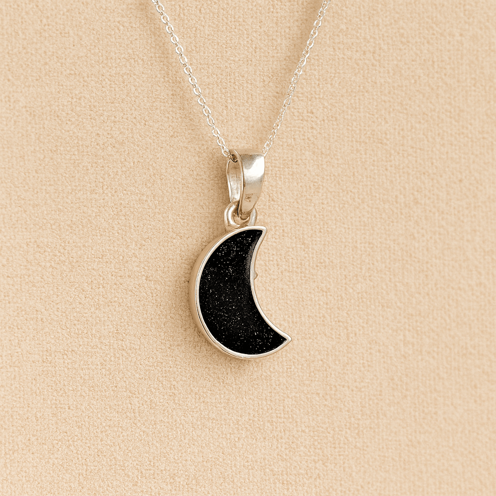 Silver Moon memorial Necklace with black resin, filled with ashes or fur, displayed on a soft beige background – suitable for pet or human memorials.