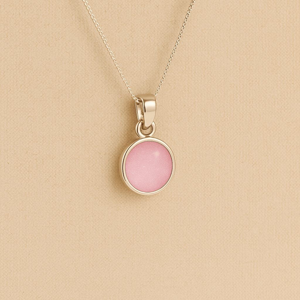 A round Silver Cremation ashes necklace light pink resin filled with ashes or fur, displayed on a soft beige background – suitable for pet or human memorials.