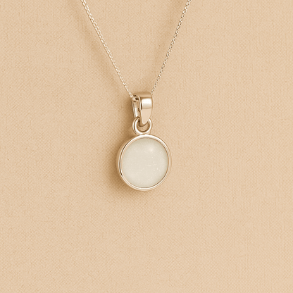Silver Cremation ashes necklace with a round pendant and white resin filled with ashes or fur, displayed on a soft beige background – suitable for pet or human memorials.