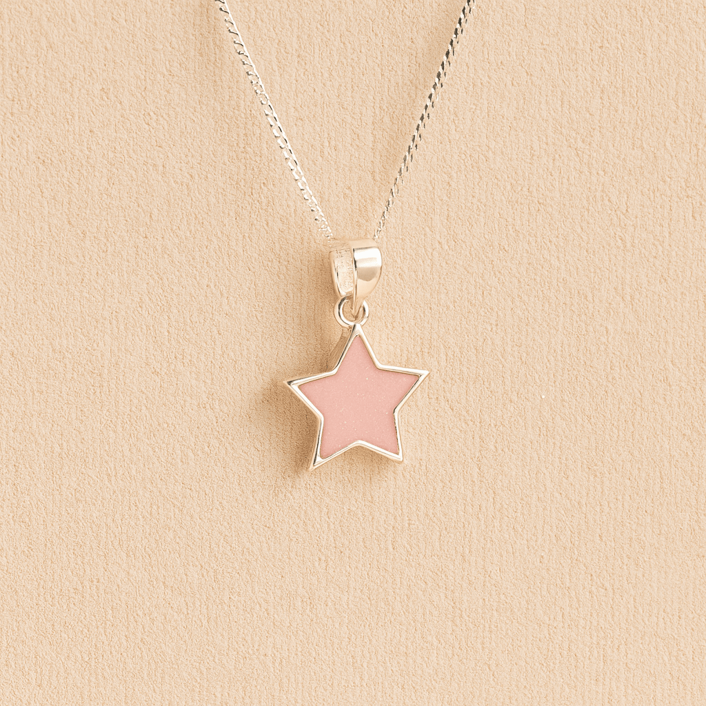 Silver star memorial pendant with light pink resin on a beige background
