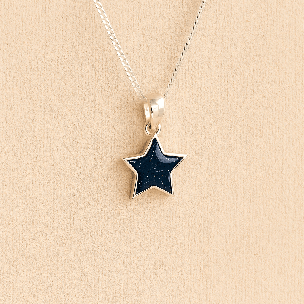 Silver star ashes asheswith navy resin on a beige background