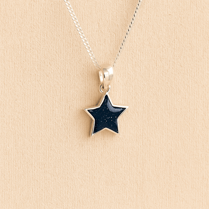 Silver star ashes asheswith navy resin on a beige background