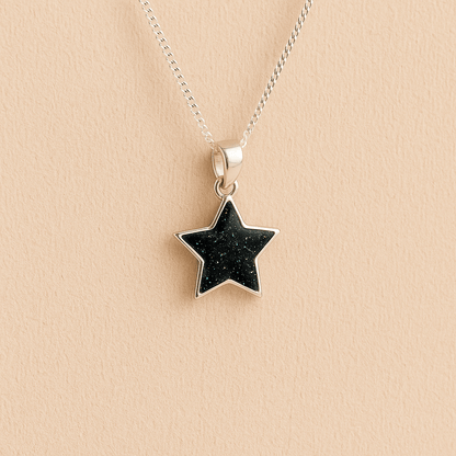 Silver star ashes pendant with Black resin on a beige background