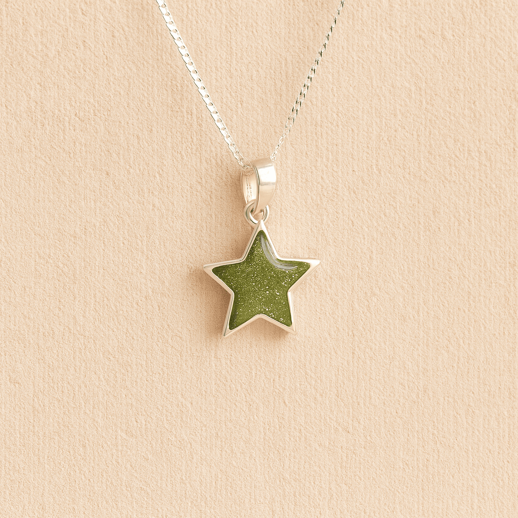 Silver star memorial necklace with sage resin on a beige background
