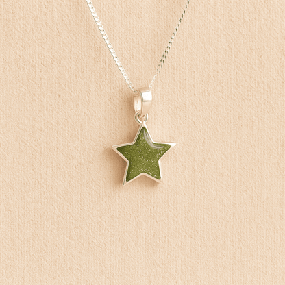 Silver star memorial necklace with sage resin on a beige background