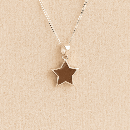 Silver star memorial necklace with mocha resin on a beige background