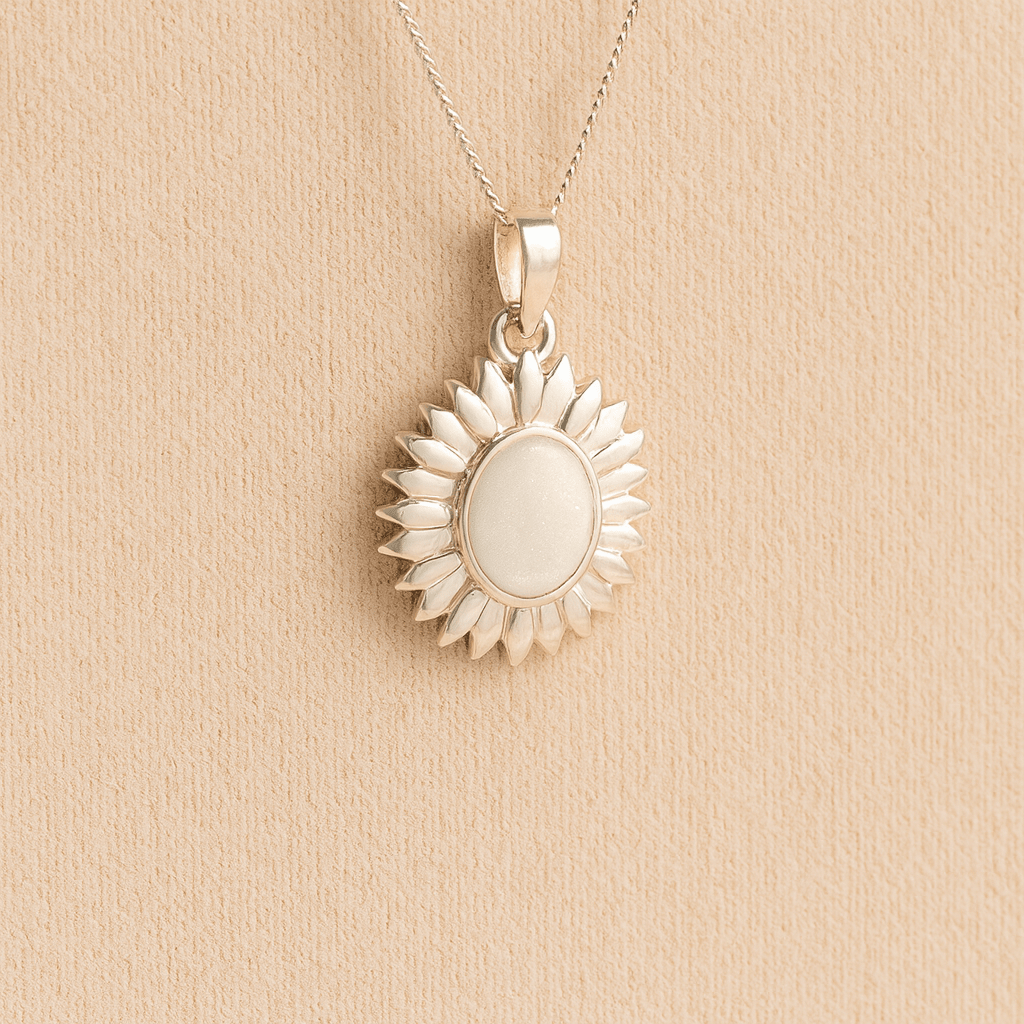 Sterling Silver Sunflower Ashes Necklace with a white resin infill containing ashes or fur set on a beige textured background