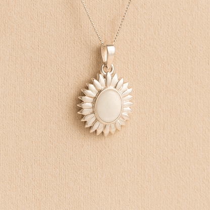 Sterling Silver Sunflower Ashes Necklace with a white resin infill containing ashes or fur set on a beige textured background