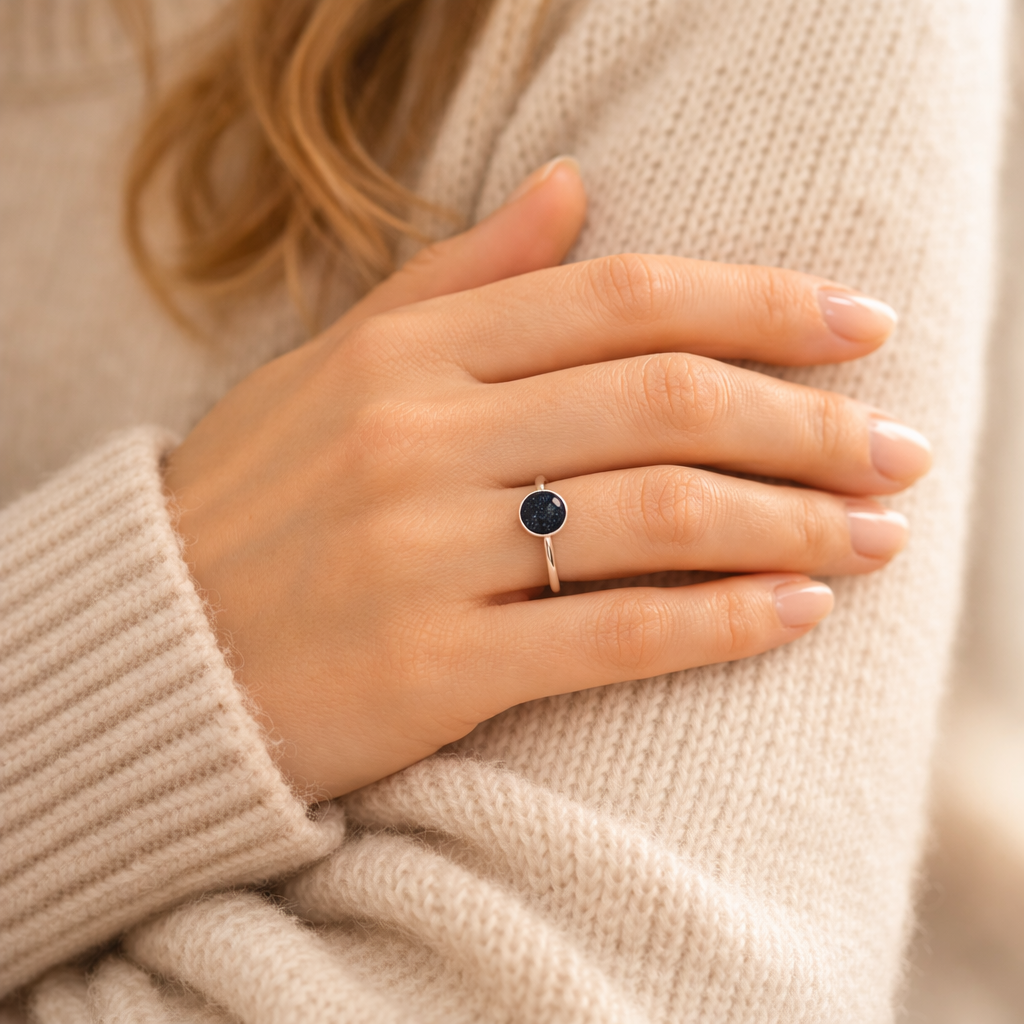 A women wearing a silver ashes cremation ring with a beige wool jumper.