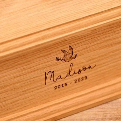 Close-up of engraved oak wood children's cremation urn – detailed view of custom memorial