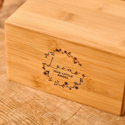 Wooden infant cremation urn engraved with baby name and floral wreath – memorial urn for a child, stillborn, or miscarriage.